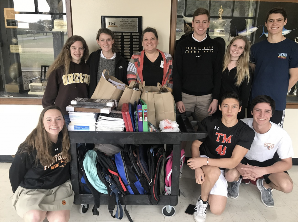 Picture of TMI students getting ready to present the school supplies they collected for children at San Antonio’s Battered Women’s and Children’s Shelter.