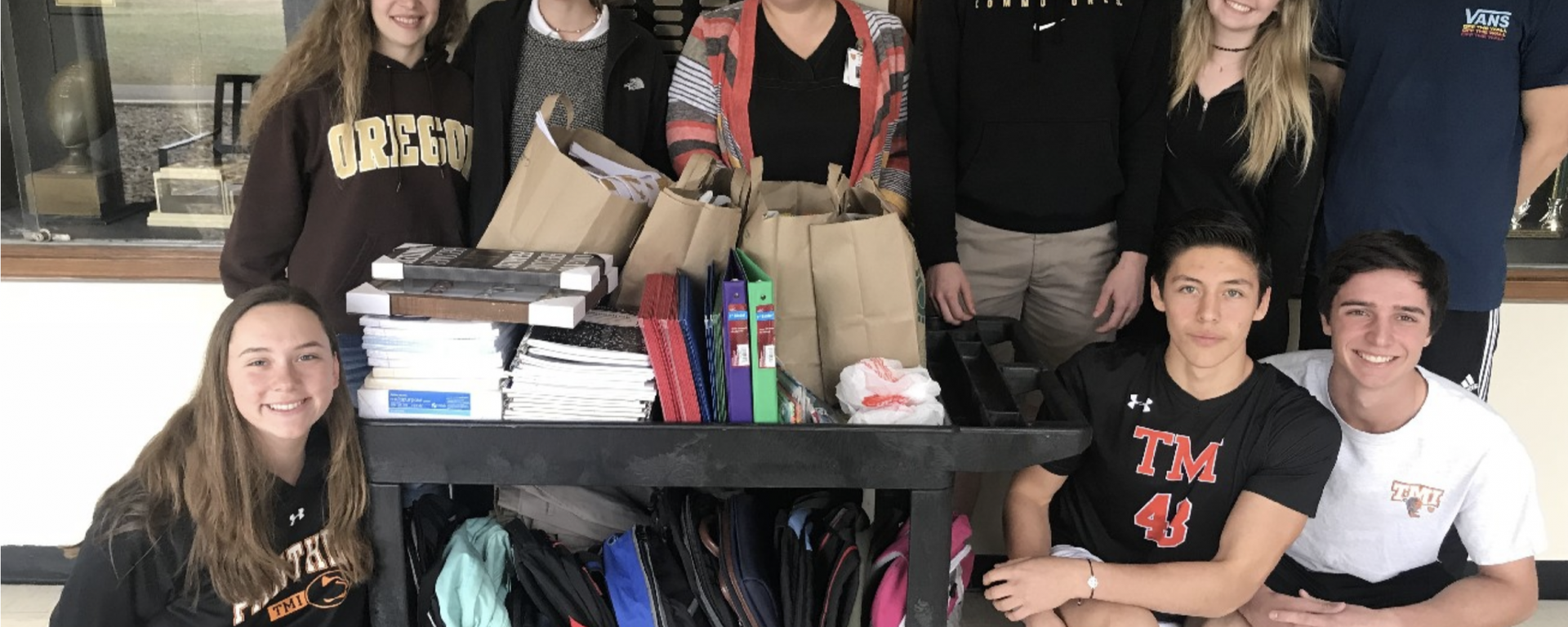 Picture of TMI students getting ready to present the school supplies they collected for children at San Antonio’s Battered Women’s and Children’s Shelter.